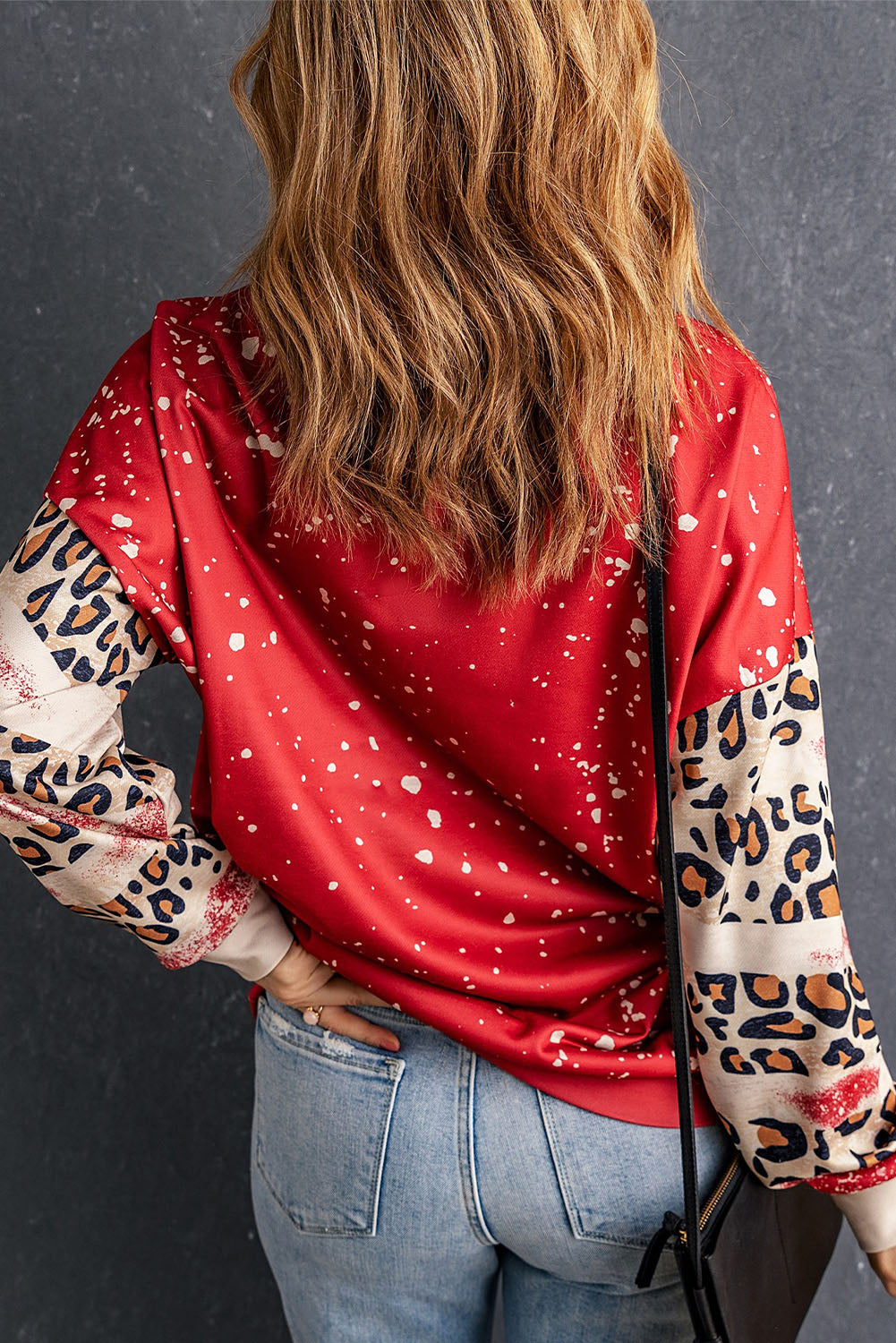 Red pullover sweatshirt featuring a heart-shaped leopard print design with a bleached effect, perfect for casual wear.