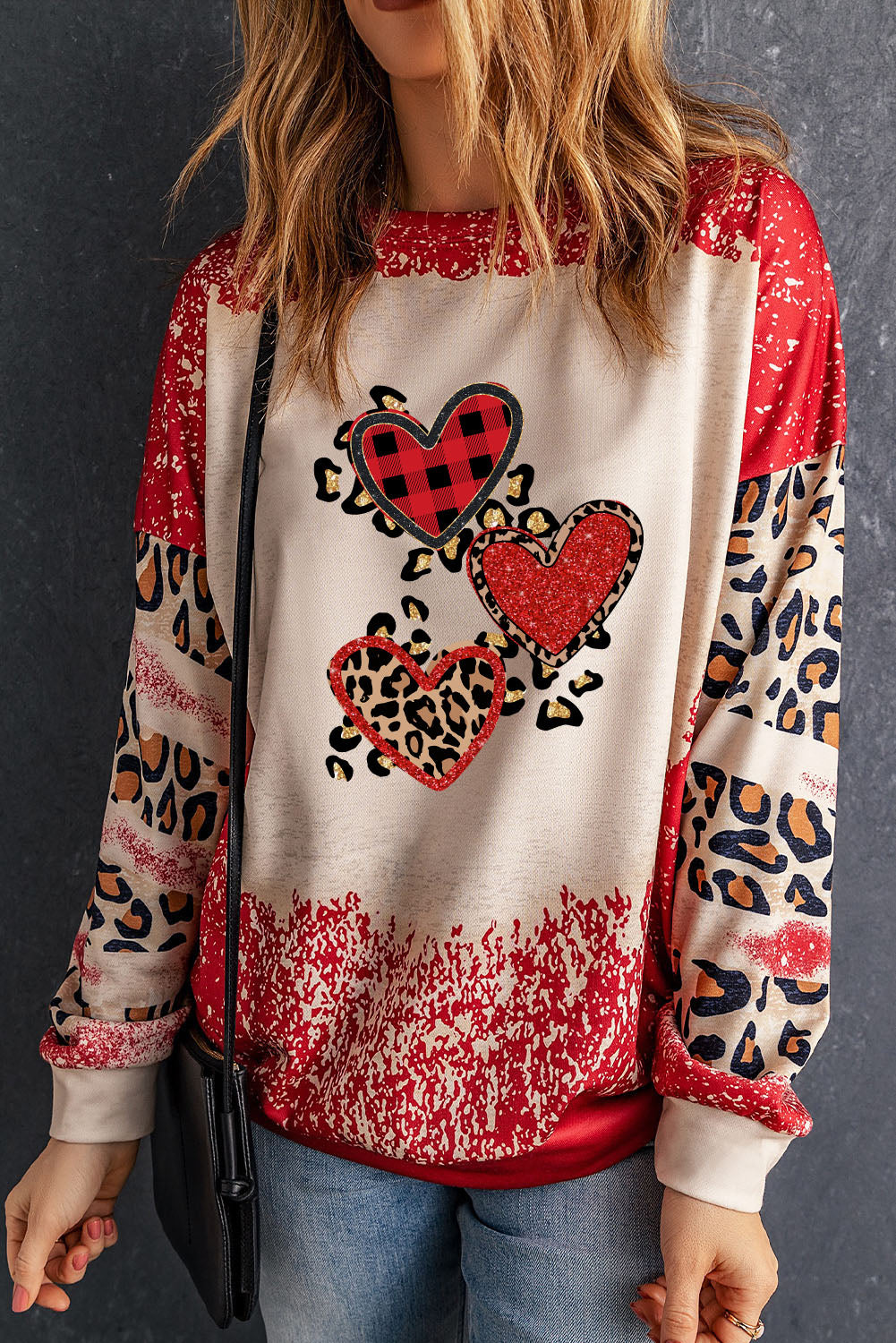 Red pullover sweatshirt featuring a heart-shaped leopard print design with a bleached effect, perfect for casual wear.