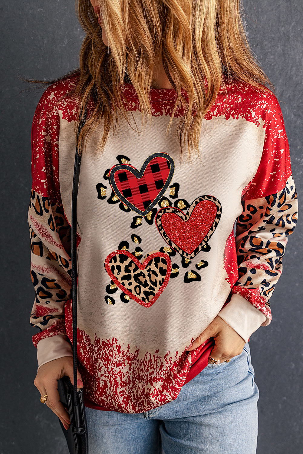 Red pullover sweatshirt featuring a heart-shaped leopard print design with a bleached effect, perfect for casual wear.