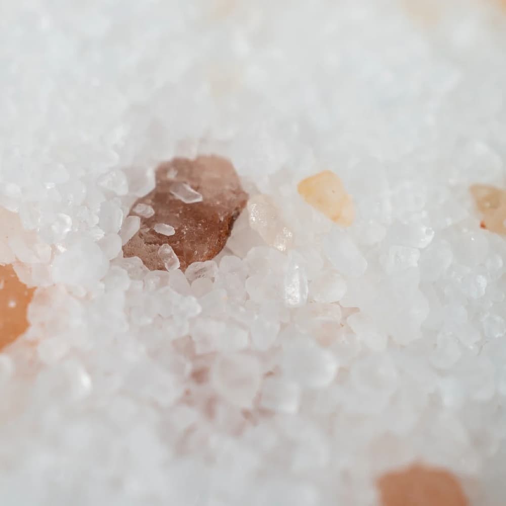 Irawo Beauty Relax Bath Salts in a clear jar, showcasing the pink and white salt crystals with a calming lavender hue, perfect for a soothing bath experience.