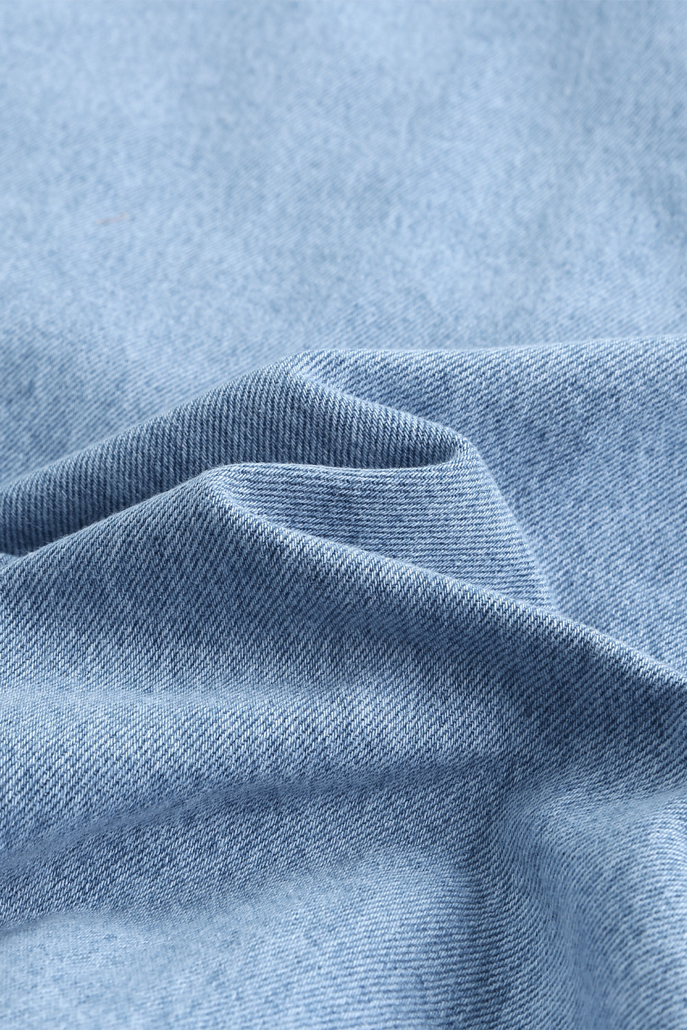 Sky blue denim shacket embellished with rhinestones and pearls, featuring a raw hemline and flap pockets.