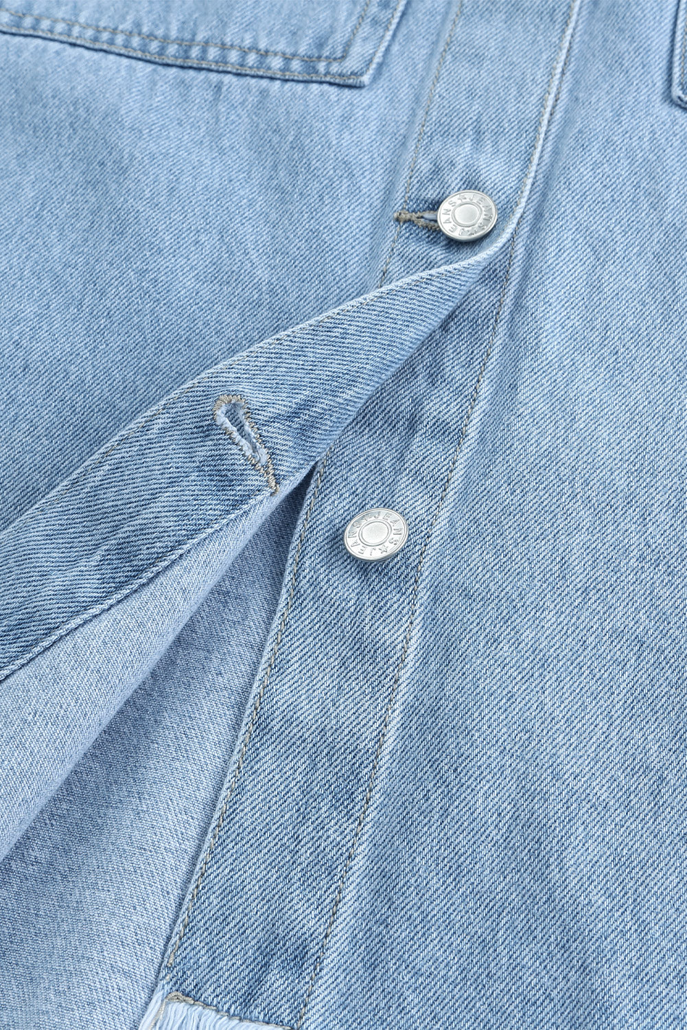 Sky blue denim shacket embellished with rhinestones and pearls, featuring a raw hemline and flap pockets.