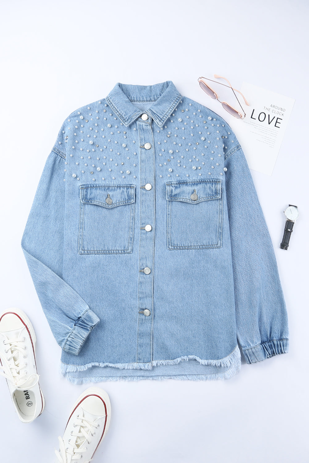Sky blue denim shacket embellished with rhinestones and pearls, featuring a raw hemline and flap pockets.