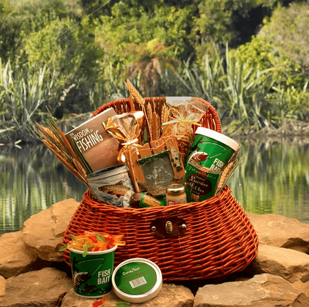 A beautifully arranged fishing gift basket featuring snacks, a fishing mug, and a wicker fishing creel, perfect for fishing enthusiasts.