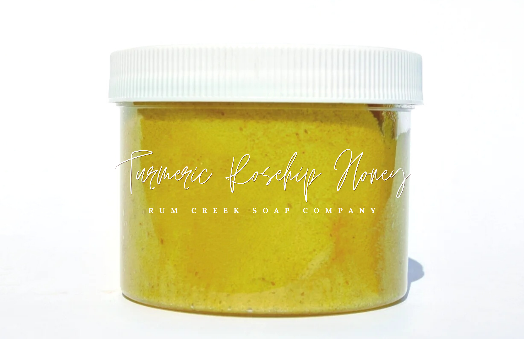 Turmeric Rosehip Honey Sugar Scrub in a clear jar, showcasing its golden sugar texture and vibrant color, surrounded by honey and rosehip flowers.