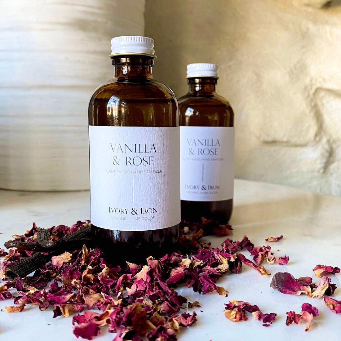 A 4 oz glass bottle of Vanilla & Rose natural hand sanitizer with a floral design, showcasing its luxurious scent and moisturizing properties.