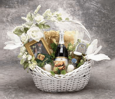 Wedding Wishes Gift Basket featuring sparkling cider, champagne glasses, gourmet snacks, and elegant white floral decorations.