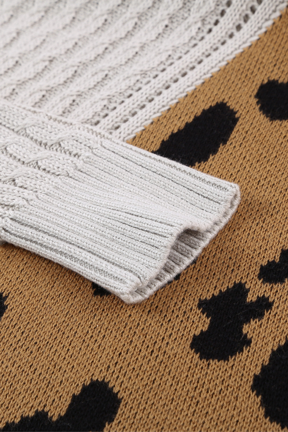 A stylish white asymmetrical sweater featuring a high neck, cold shoulder design, and buckle strap, perfect for chic outfits.