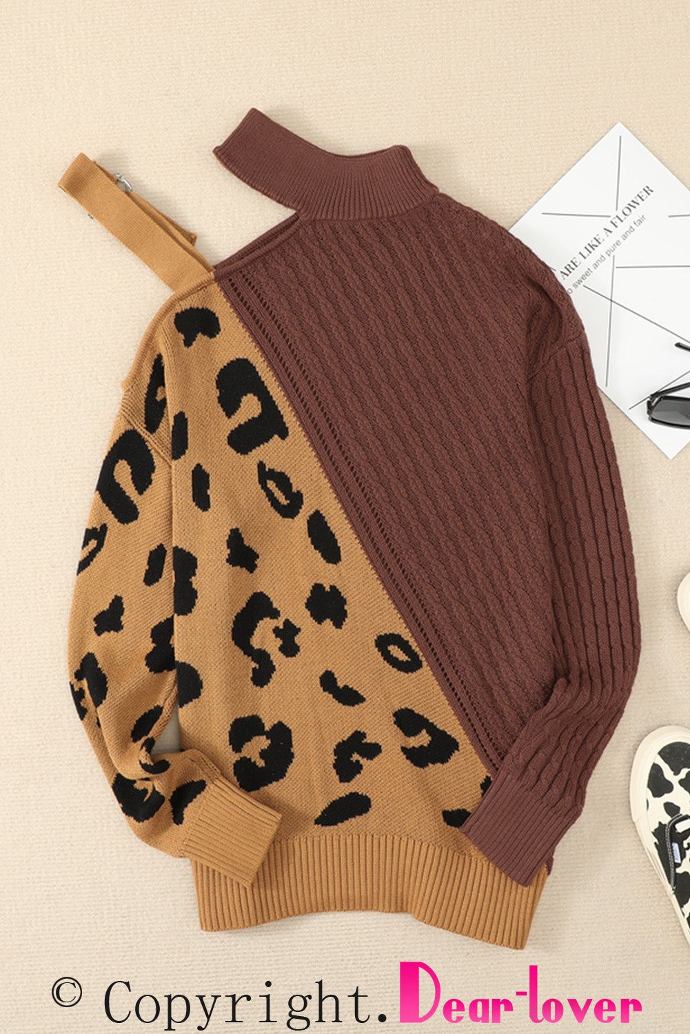 A stylish white asymmetrical sweater featuring a high neck, cold shoulder design, and buckle strap, perfect for chic outfits.