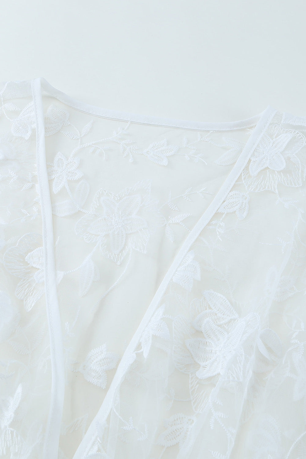 A beautiful white floral mesh lace crochet kimono with an open front, showcasing delicate lace details and a loose fit, perfect for summer wear.