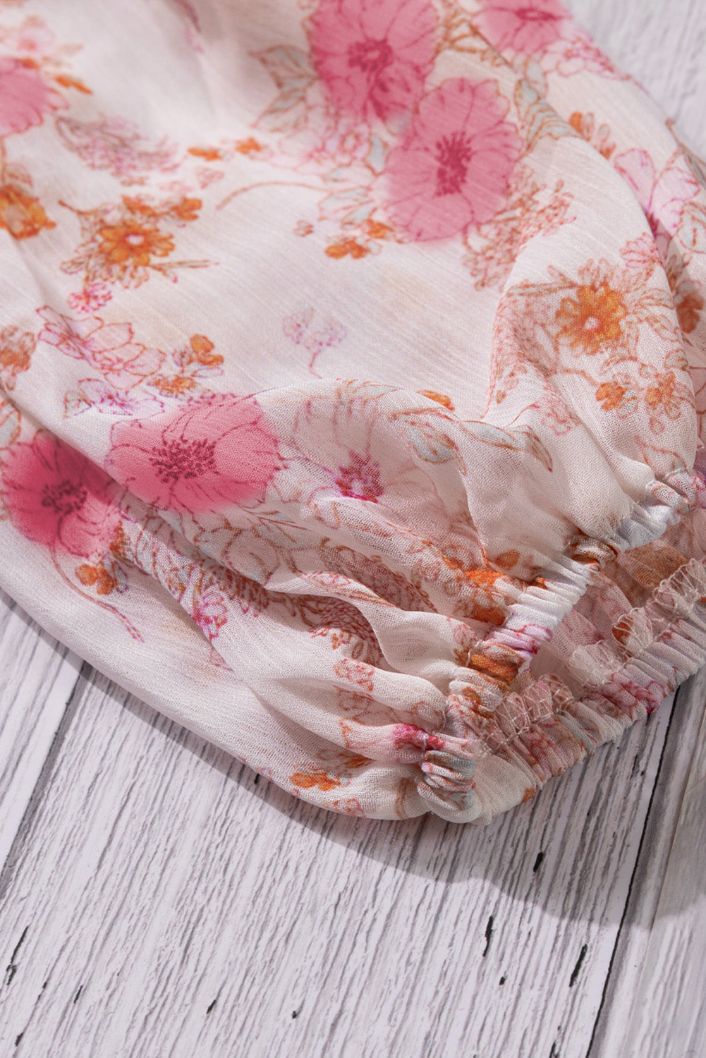 A stylish white top featuring a floral print, V-neckline, and long puff sleeves, perfect for casual and formal occasions.