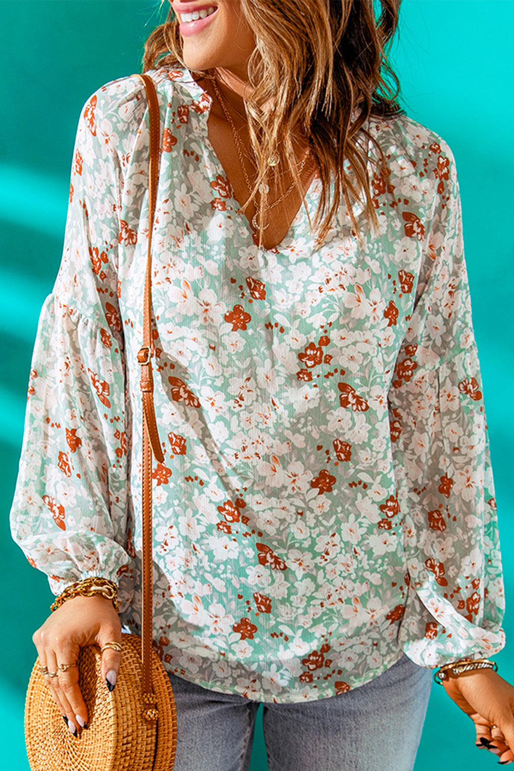 A stylish white top featuring a floral print, V-neckline, and long puff sleeves, perfect for casual and formal occasions.