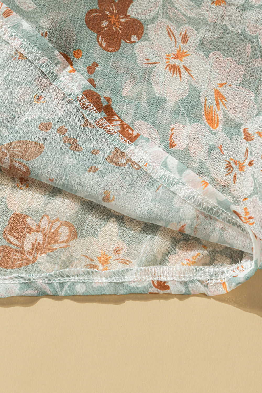 A stylish white top featuring a floral print, V-neckline, and long puff sleeves, perfect for casual and formal occasions.