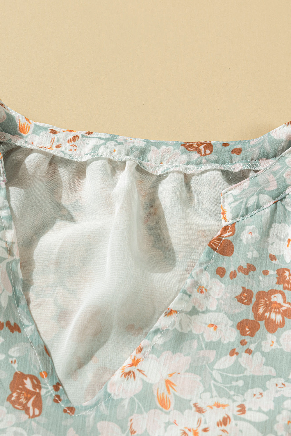 A stylish white top featuring a floral print, V-neckline, and long puff sleeves, perfect for casual and formal occasions.