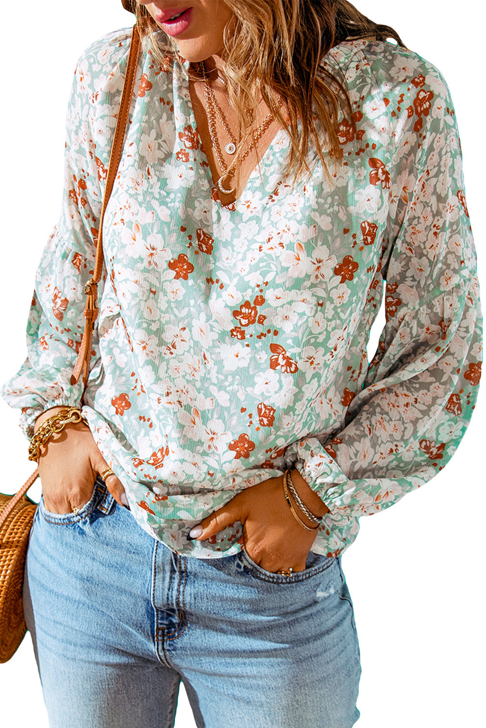 A stylish white top featuring a floral print, V-neckline, and long puff sleeves, perfect for casual and formal occasions.