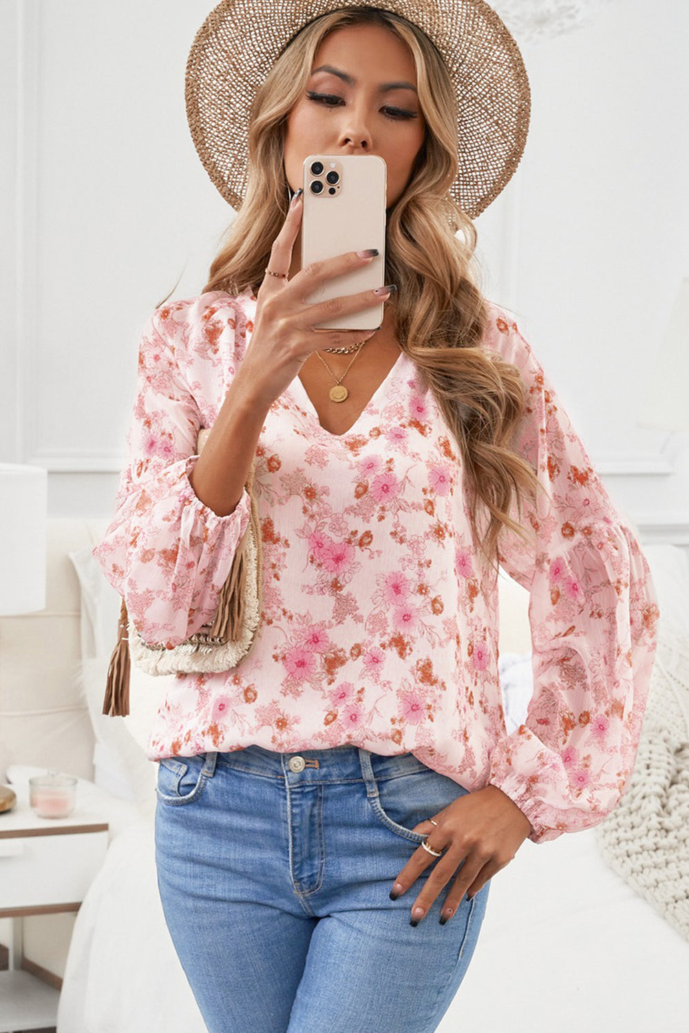 A stylish white top featuring a floral print, V-neckline, and long puff sleeves, perfect for casual and formal occasions.