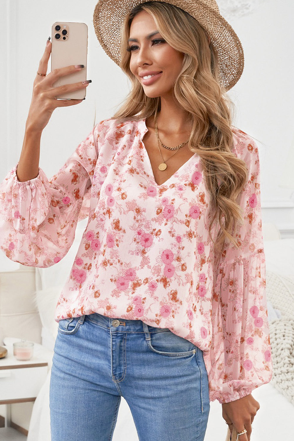 A stylish white top featuring a floral print, V-neckline, and long puff sleeves, perfect for casual and formal occasions.