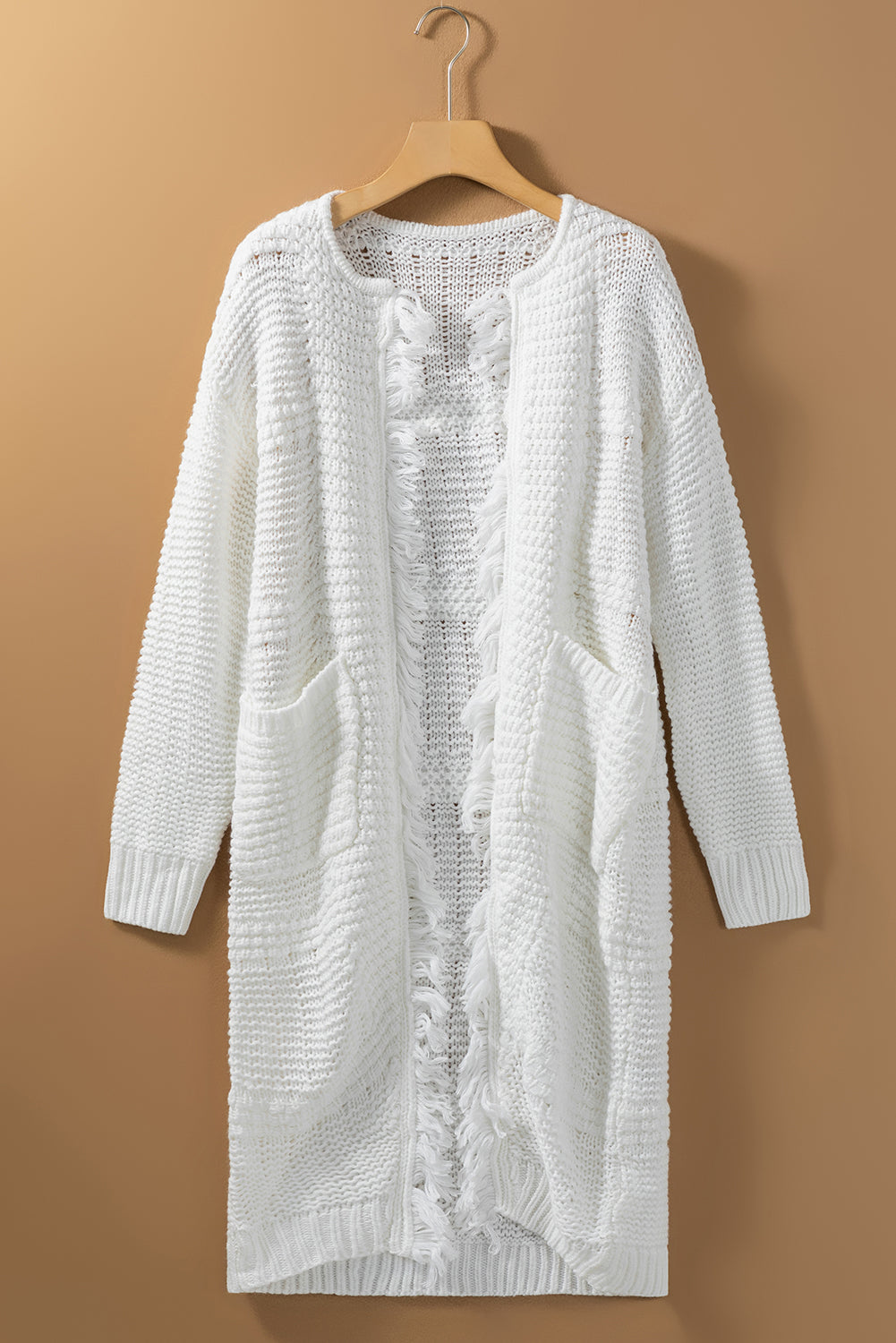 A stylish white long cardigan with fringed edges and open front, featuring two pockets, perfect for layering and adding elegance to any outfit.