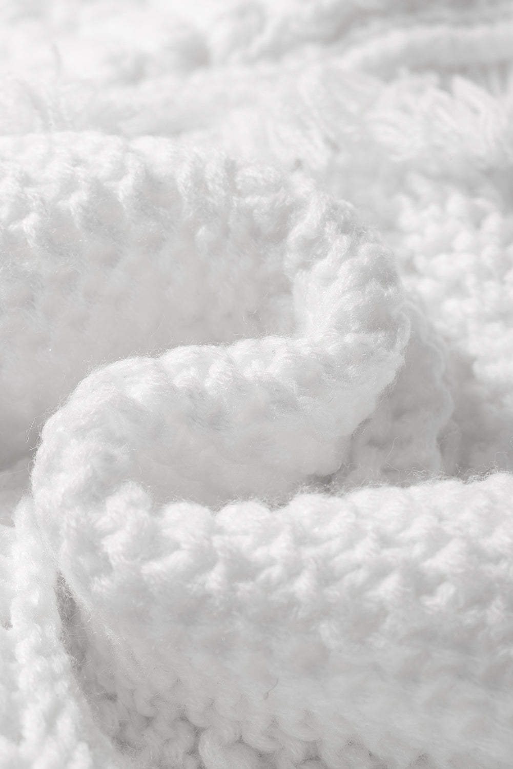 A stylish white long cardigan with fringed edges and open front, featuring two pockets, perfect for layering and adding elegance to any outfit.