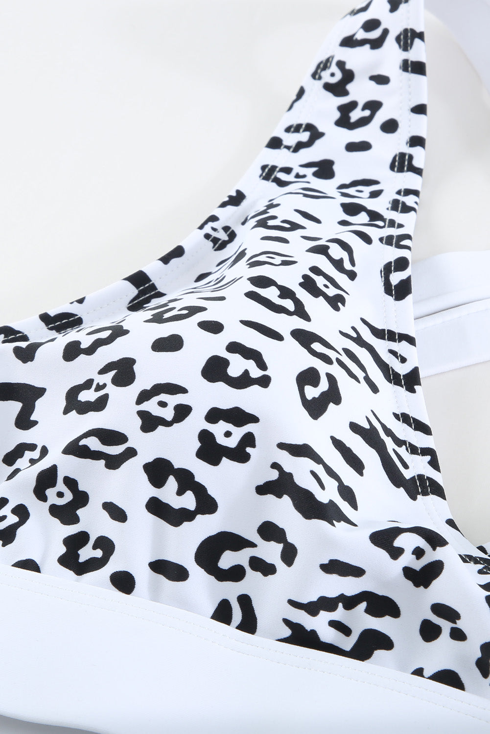 White leopard print criss cross bikini set featuring a deep V neckline and criss-cross back design, perfect for summer beach outings.