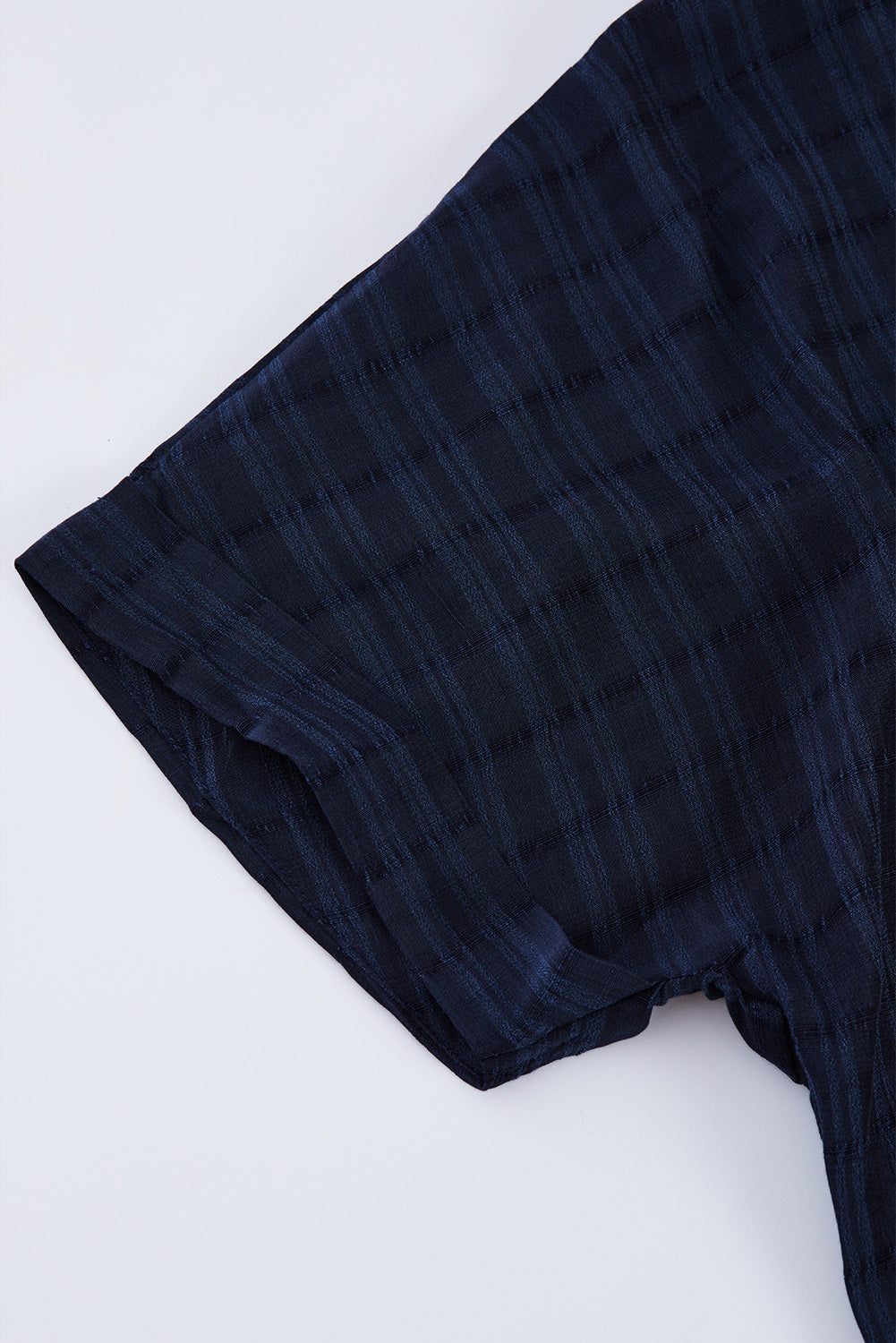 A stylish white plaid print loose V neck short sleeve shirt with slits, showcasing its trendy design and comfortable fit.