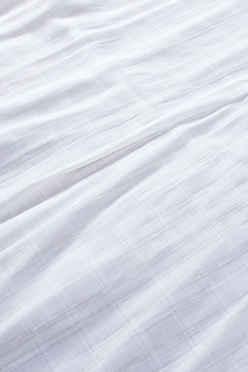 A stylish white plaid print loose V neck short sleeve shirt with slits, showcasing its trendy design and comfortable fit.