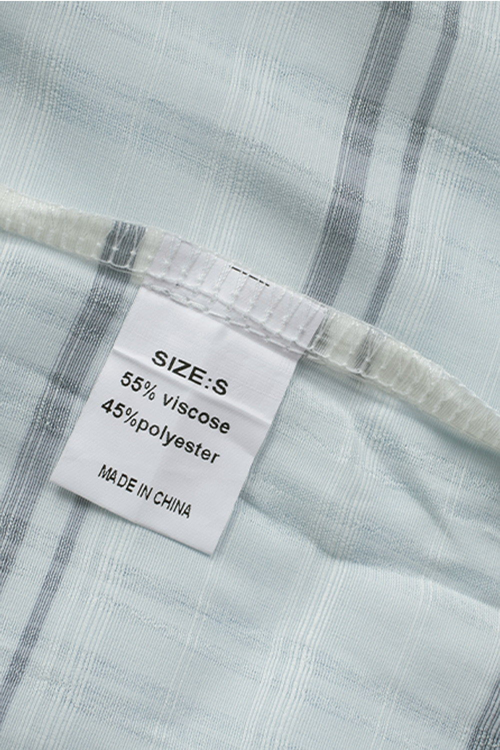 A stylish white plaid print loose V neck short sleeve shirt with slits, showcasing its trendy design and comfortable fit.