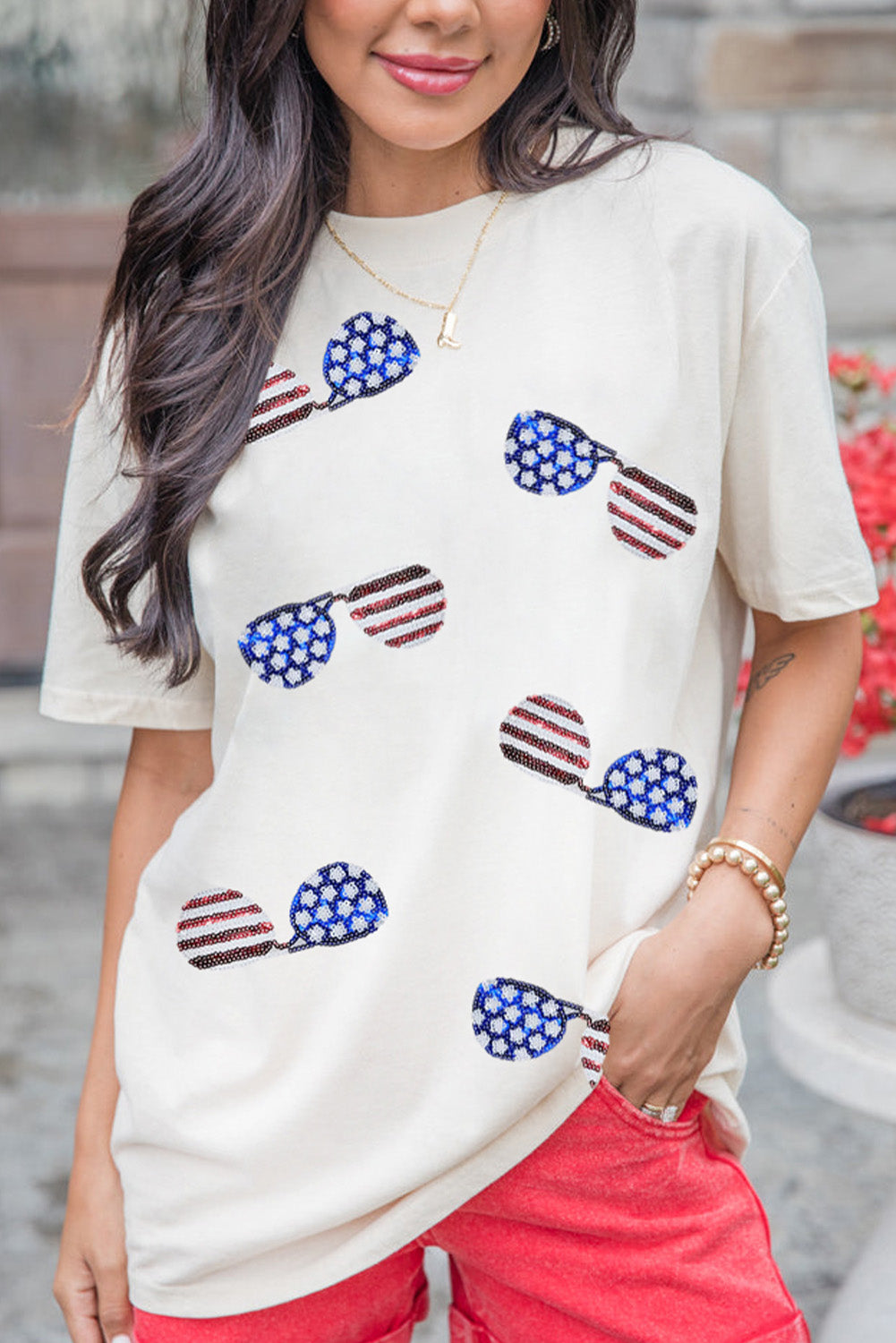 White crew neck t-shirt featuring a sequined American flag design with sunglasses, perfect for casual wear.