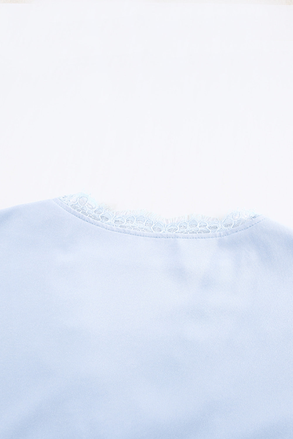 A stylish white V neck t-shirt featuring a delicate lace trim, showcasing its relaxed fit and elegant design.