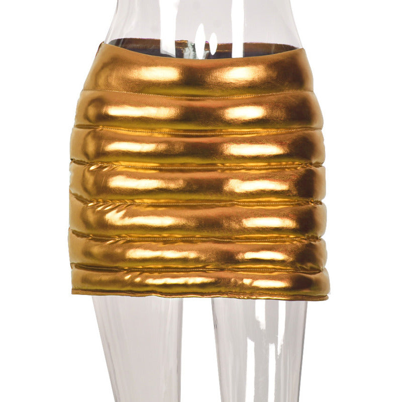 A stylish gold women's puffer skirt featuring a metallic shiny finish, quilted design, and a mini A-line silhouette, perfect for various occasions.