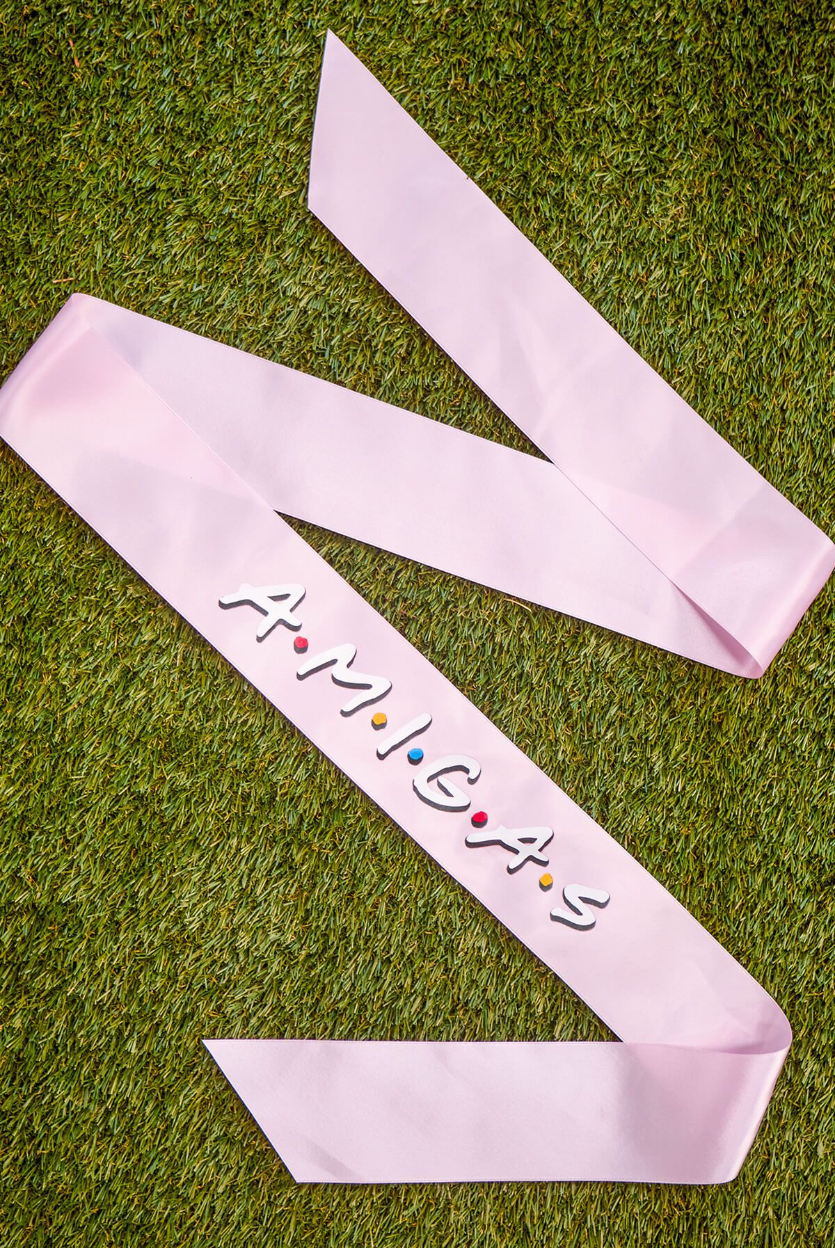 A set of FRIENDS bachelorette party sashes featuring shiny leopard foil design on white satin ribbon, perfect for brides and their amigas.