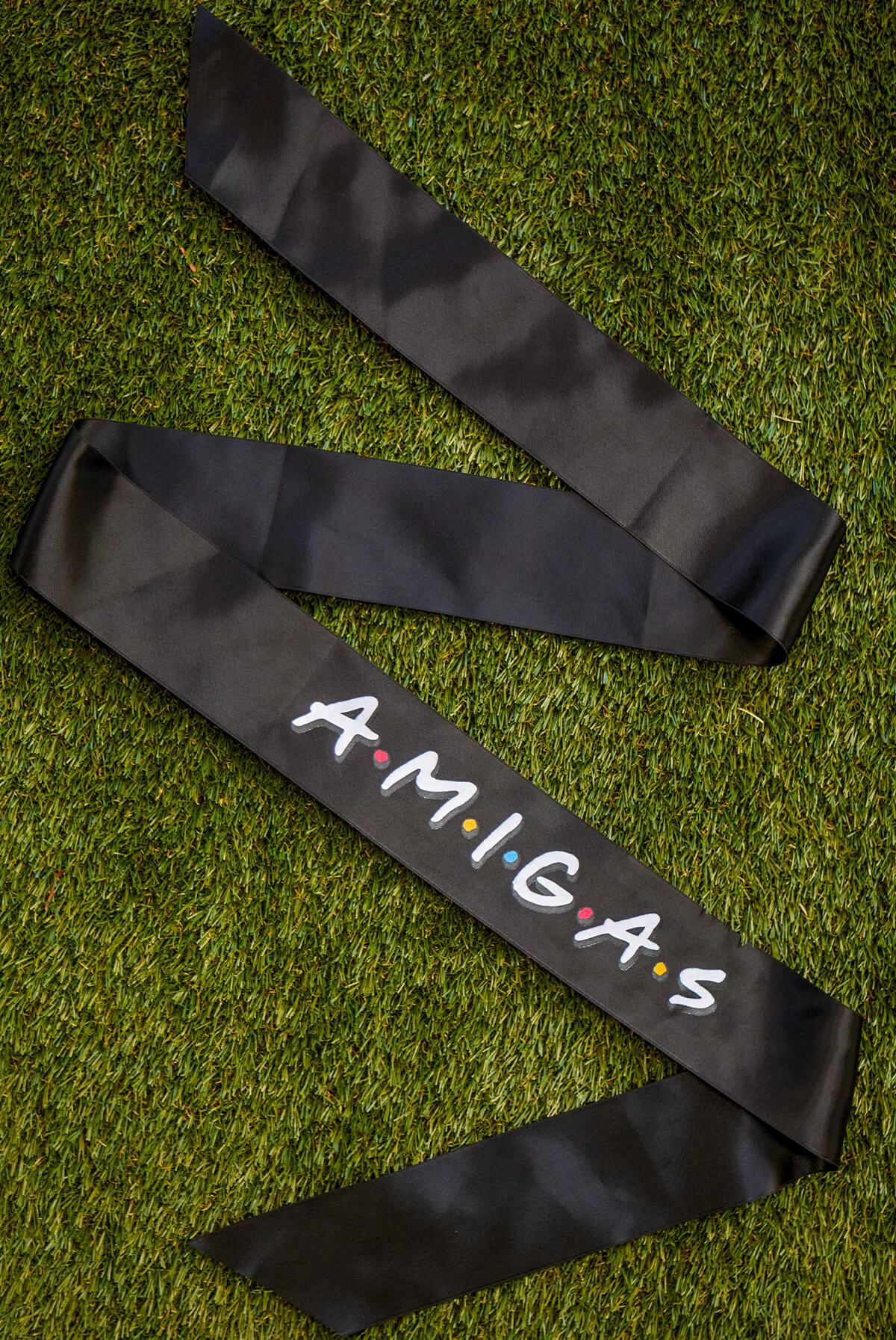 A set of FRIENDS bachelorette party sashes featuring shiny leopard foil design on white satin ribbon, perfect for brides and their amigas.