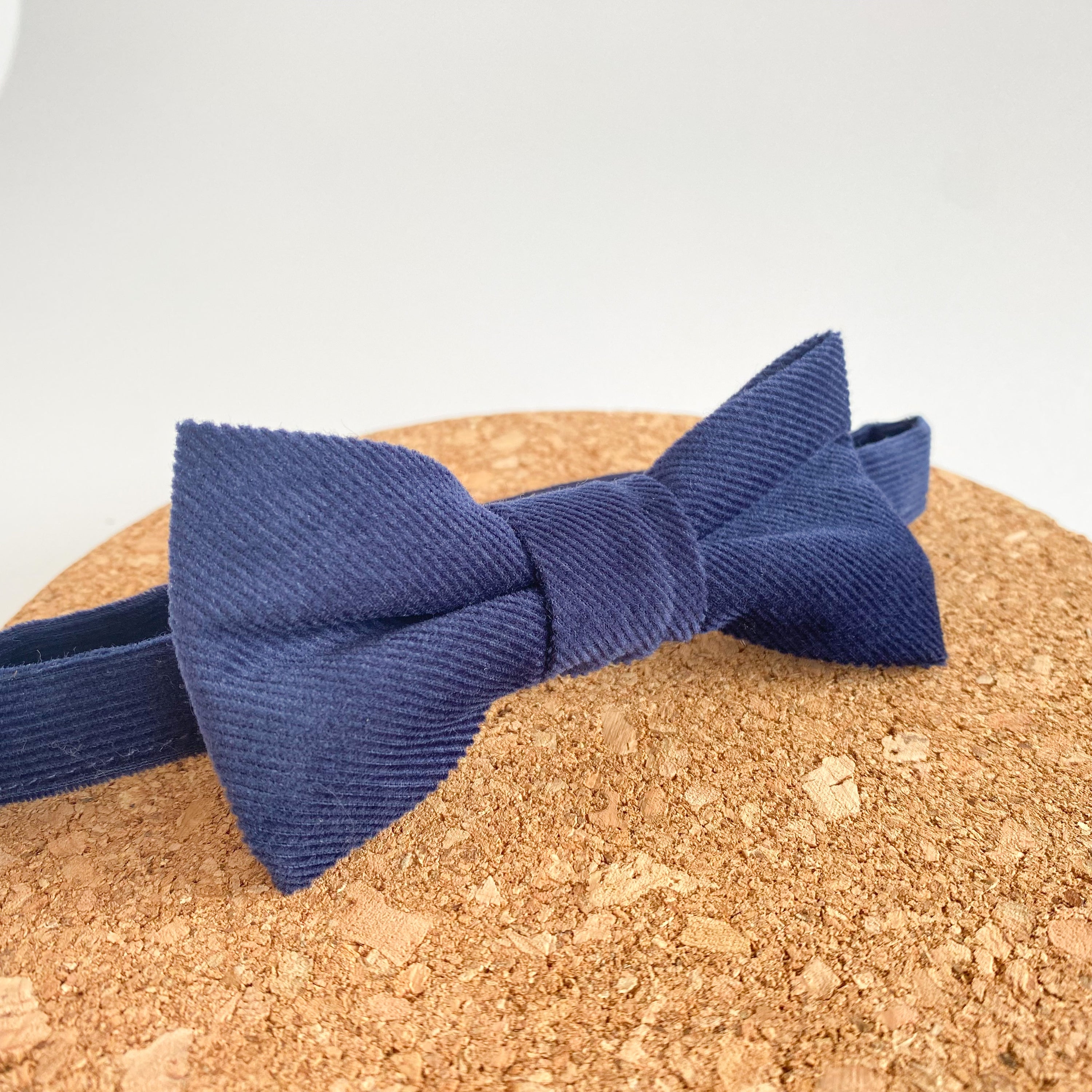 Handmade denim blue corduroy bow tie for boys, featuring a pre-tied design and velcro fastening.