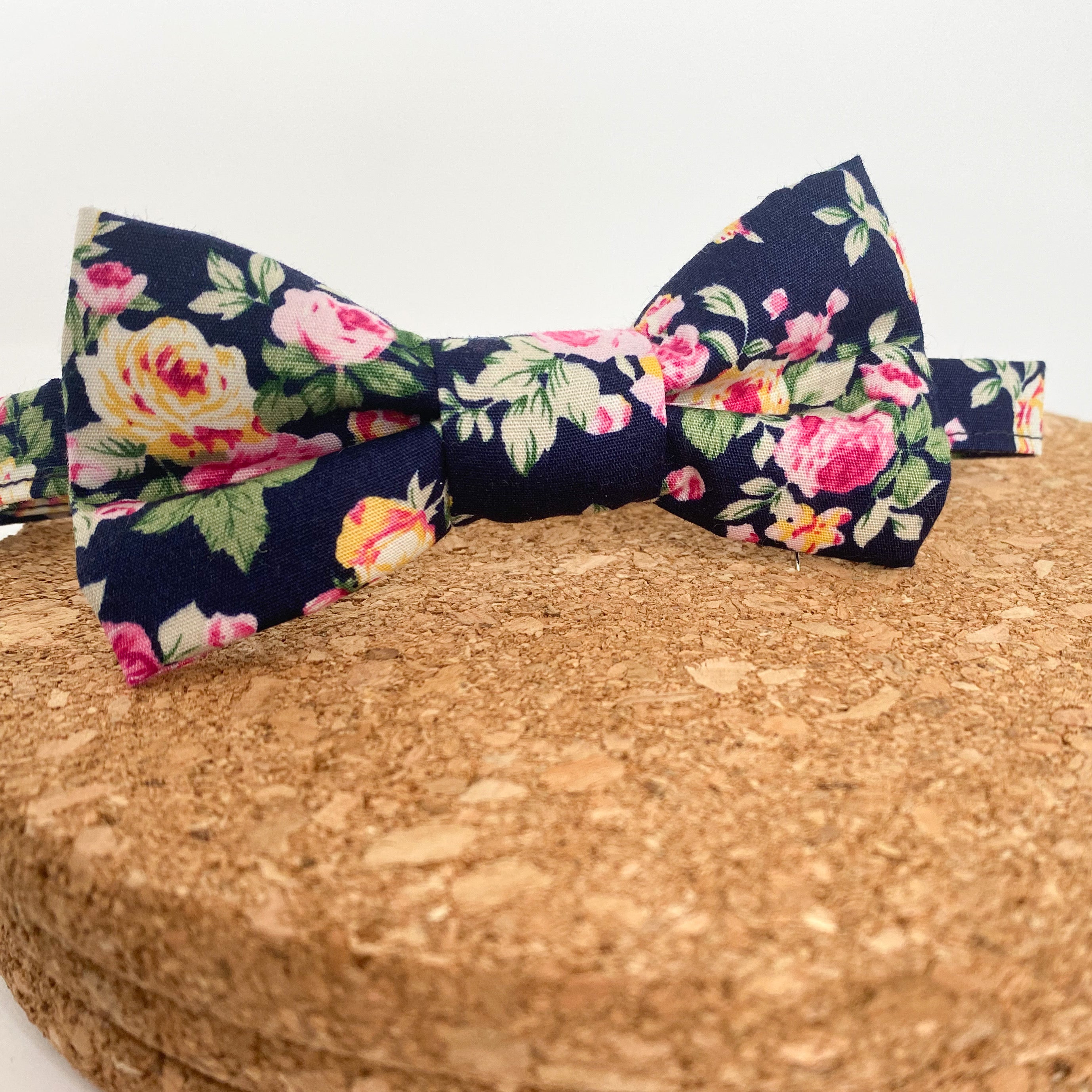 JAMESON Boys Bow Tie featuring pink and yellow roses on a navy background, handmade in England with velcro fastening.
