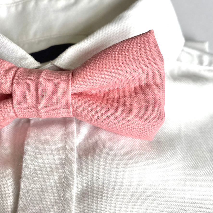 A handmade pale pink boys bow tie with a velcro fastening, perfect for weddings and special occasions, displayed on a white background.