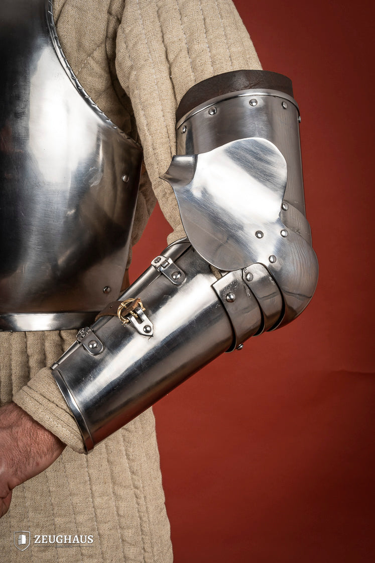 Polished Arm Armour 1390-1450 featuring leather straps and winged couter for elbow protection, showcasing medieval craftsmanship.