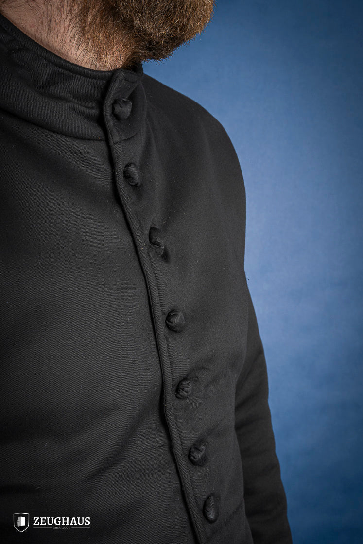 A black 15th-century style arming doublet made of cotton, featuring reinforced armholes and polyester-wool padding, ideal for historical reenactments.