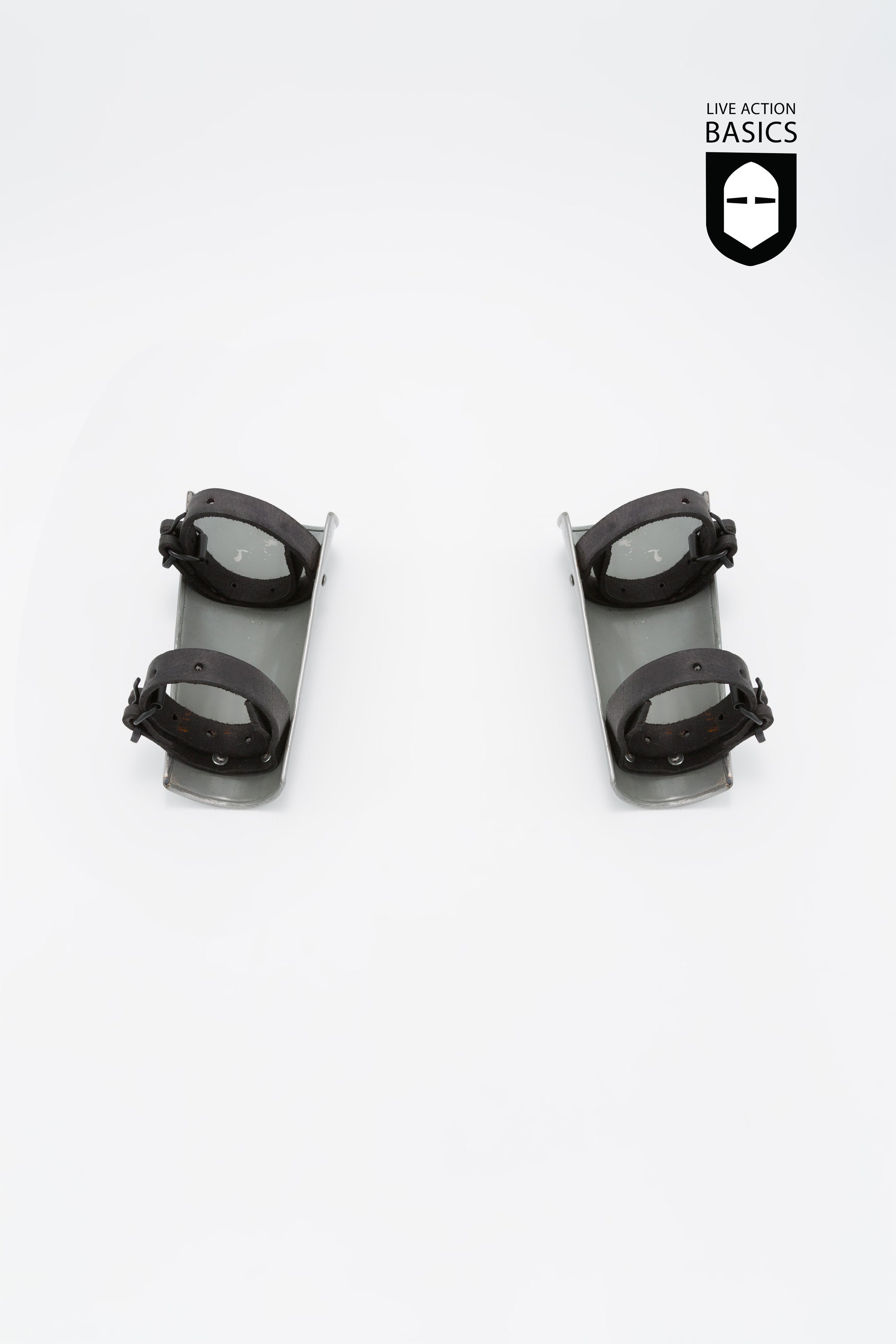 A pair of Basic Bracers made from mild steel, featuring adjustable straps for a secure fit, designed for arm and wrist protection.