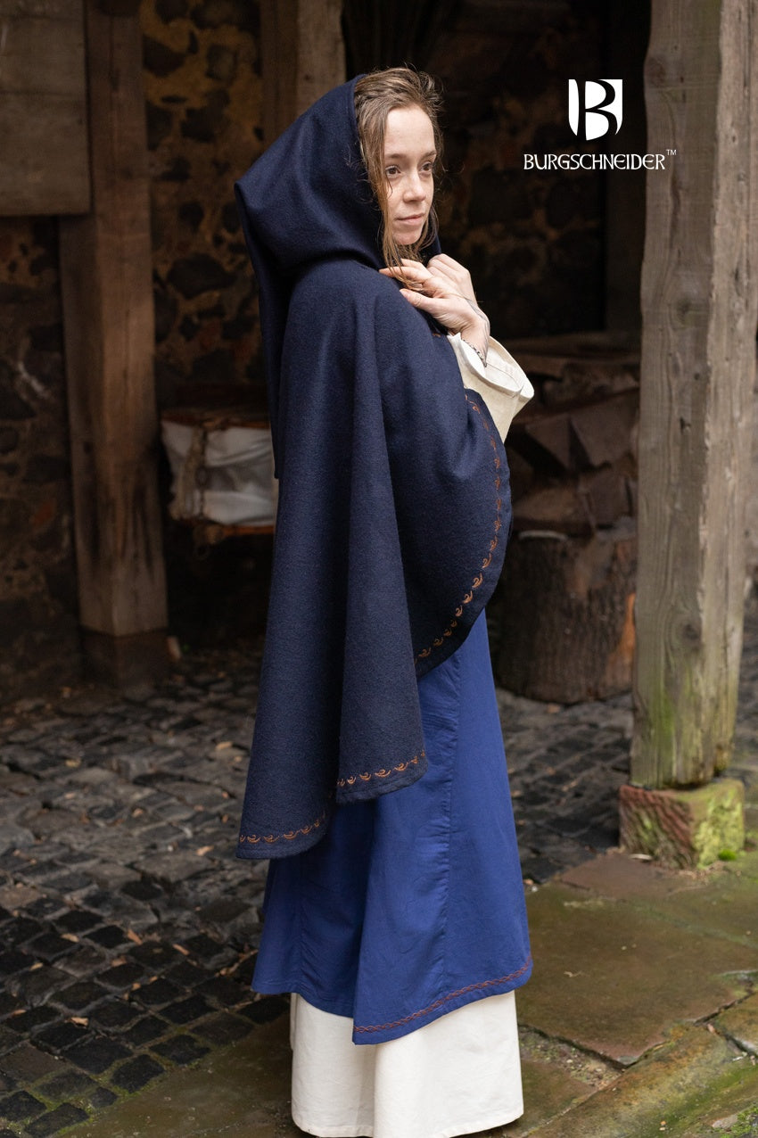 Cape Affra Blue made of wool felt with ornamental embroidery and a long pointed hood, showcasing its unique design.