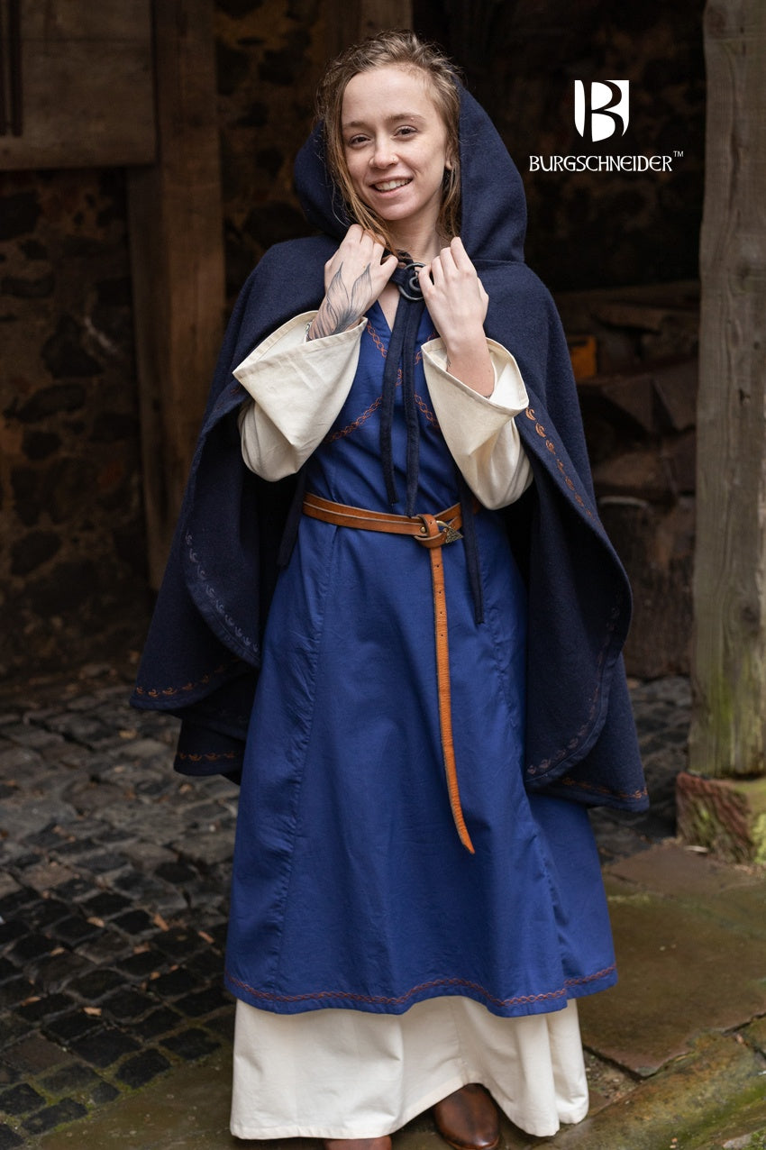 Cape Affra Blue made of wool felt with ornamental embroidery and a long pointed hood, showcasing its unique design.