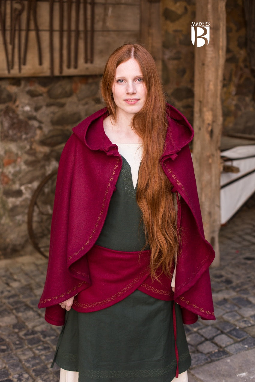 A vibrant red wool felt cape with a long pointed hood and ornamental embroidery, showcasing its unique design and double lacing closure.