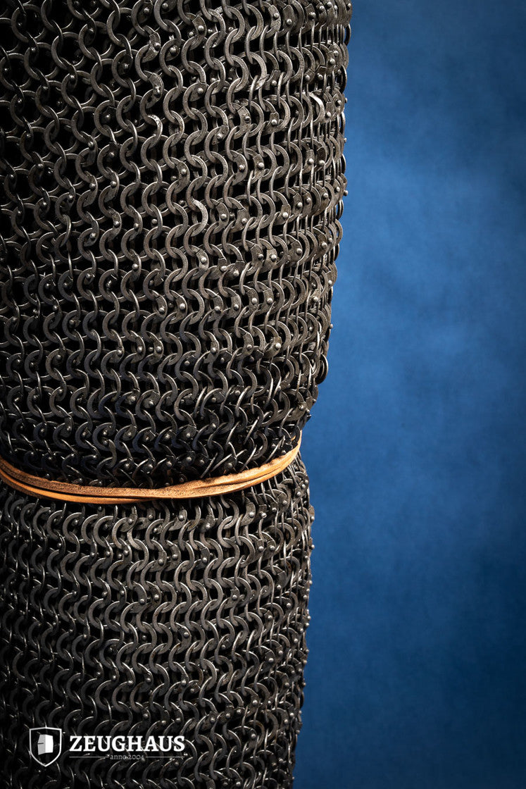 Chainmail chausses made of 9mm oiled mild steel, featuring flat rings and riveted construction, ideal for historical reenactments.