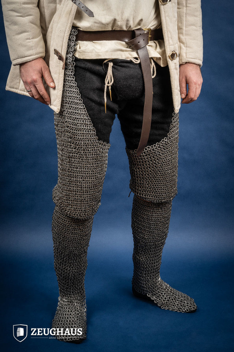 Chainmail chausses made of 9mm oiled mild steel, featuring flat rings and riveted construction, ideal for historical reenactments.