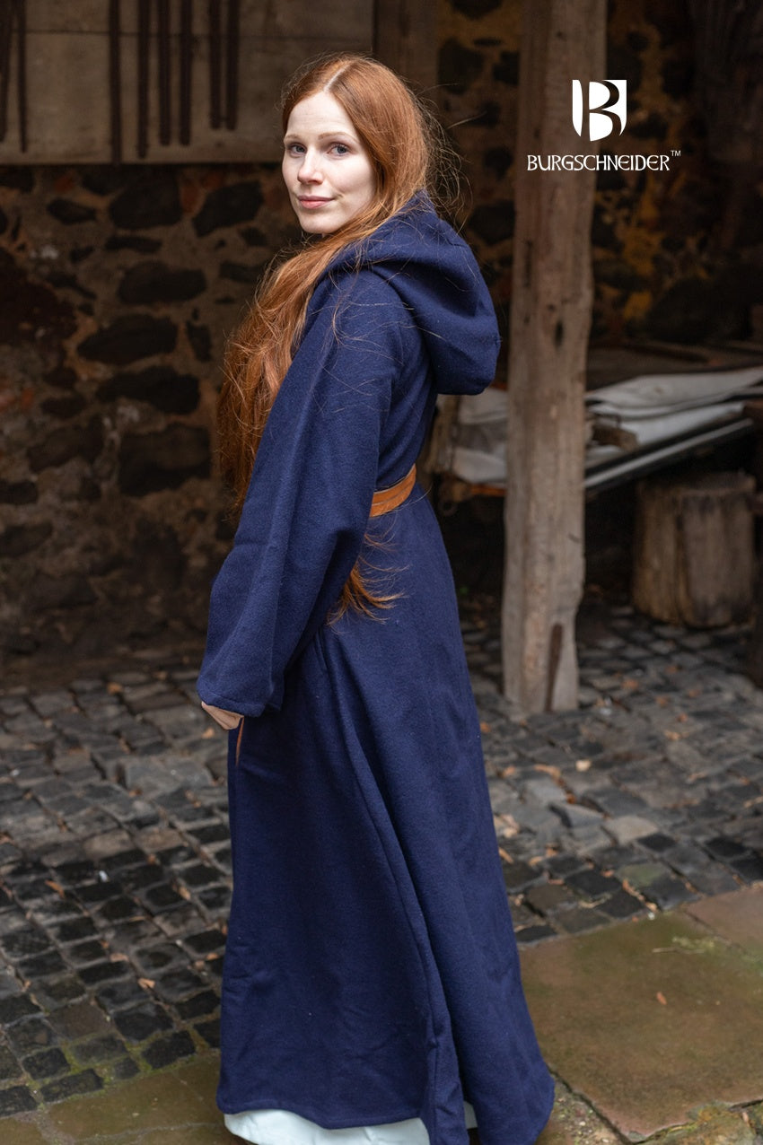 Tuala Blue Coat made of warm wool felt with solid brass buttons, featuring a large hood and flared sleeves.