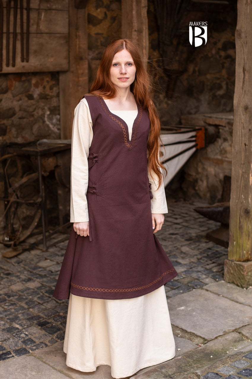 Elegant light brown sleeveless dress with side lacing and ornamental embroidery, flowing design inspired by medieval bliaut.