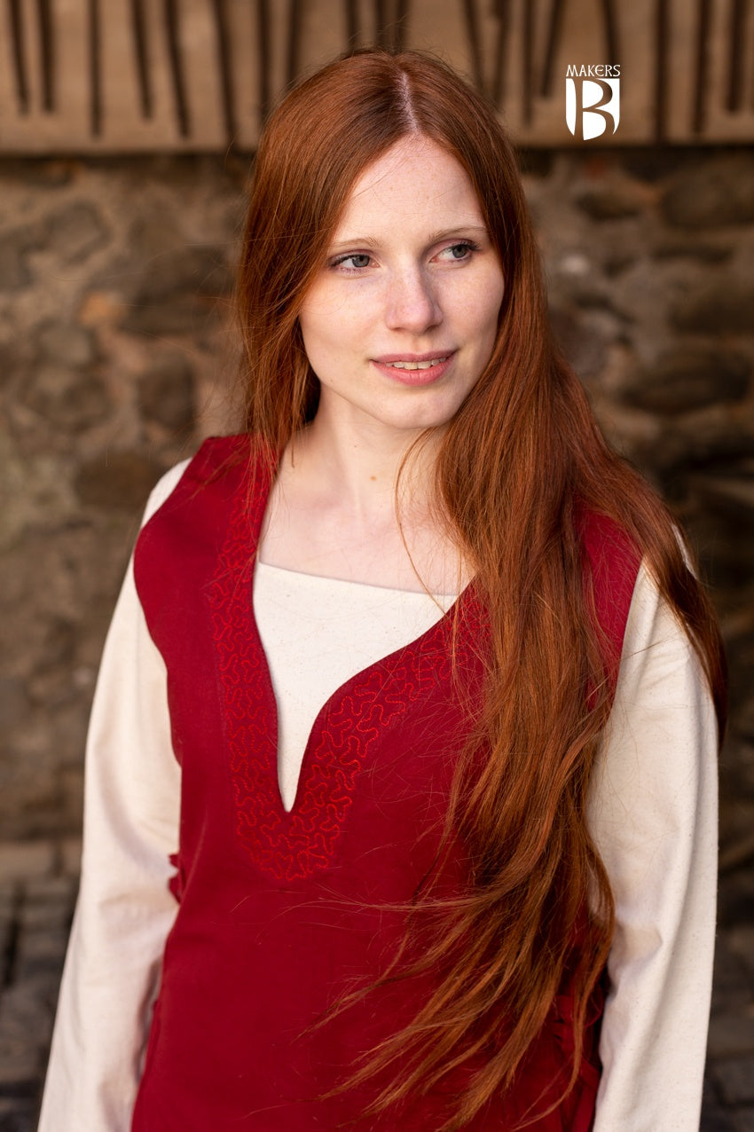 A beautiful red sleeveless dress made of fine cotton, featuring side lacing, ornamental embroidery at the neckline and hem, and a flowing design.