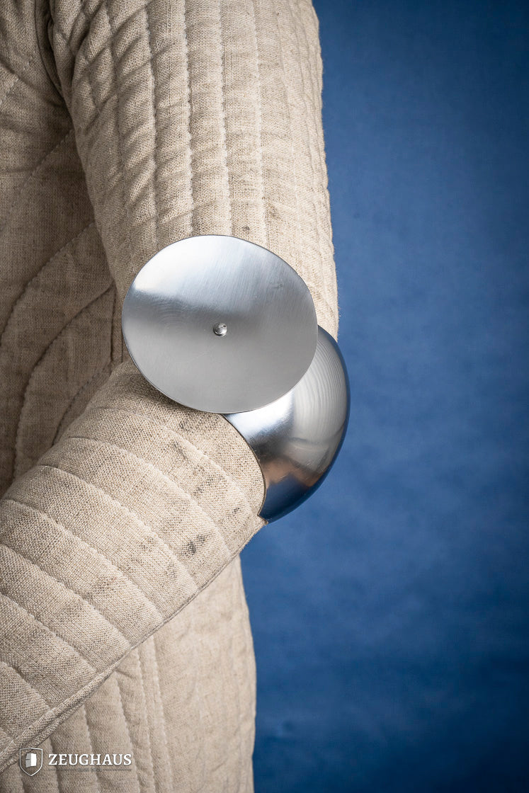 Polished 1.6mm steel elbow caps showcasing craftsmanship and durability.