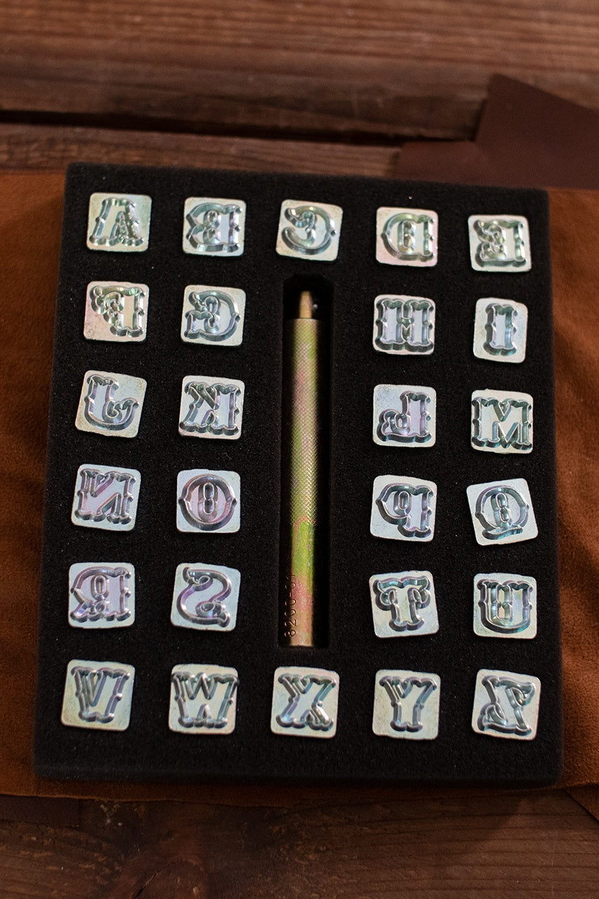 Embossing Tool Set Alphabet STANDARD featuring 26 iron stamps and 1 iron handle, ideal for personalizing leather crafts.