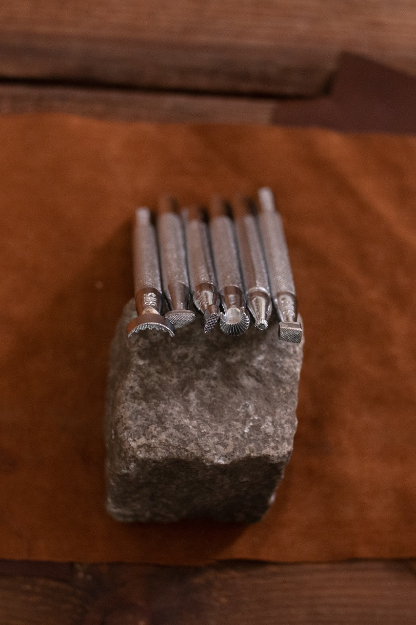 Embossing Tool Set featuring 7 iron tools including a swivel knife, designed for leather crafting.