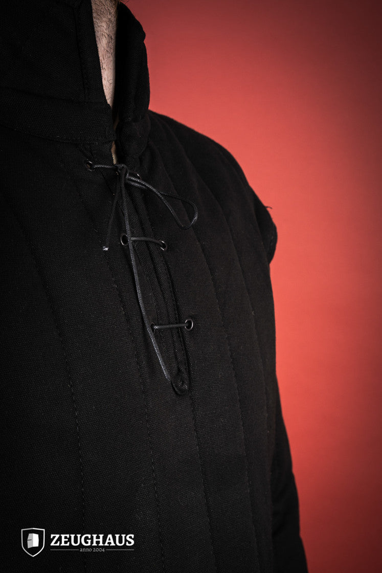 Black gambeson featuring side buckles and modified neckline, inspired by medieval illustrations.